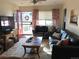 Sunlit living room with a floral rug, leather sofas, and an open red front door leading to outdoor views at 5618 Carr St, Arvada, CO 80002