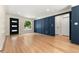 Open living room featuring hardwood floors, modern blue paneling, and recessed lighting at 1045 Locust St, Denver, CO 80220