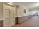 Hallway with framed art on walls leads to the front door, with decorative door hardware at 13850 E Marina Dr # 506, Aurora, CO 80014