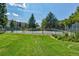 View of a fenced tennis court, well maintained, with surrounding green space and community buildings at 13850 E Marina Dr # 506, Aurora, CO 80014