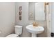 Cozy powder room features modern fixtures, a pedestal sink, and artistic wall decor at 6364 Fulton St, Denver, CO 80238