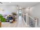 Well-lit hallway with hardwood floors, modern staircase, and views into the living room at 6364 Fulton St, Denver, CO 80238
