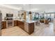 Spacious kitchen with stainless steel appliances, wood cabinets, large center island and open to the living room at 6364 Fulton St, Denver, CO 80238