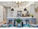 Bright eat-in kitchen features stainless appliances, white cabinets, breakfast bar, and stylish pendant lighting at 6364 Fulton St, Denver, CO 80238