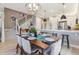 Open concept kitchen with white cabinets, stainless appliances, island with seating and adjacent dining area at 6364 Fulton St, Denver, CO 80238