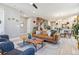Open-concept living space featuring hardwood floors, stylish seating, and a view into the modern kitchen at 6364 Fulton St, Denver, CO 80238
