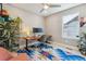 Bright office features a ceiling fan, large window, modern desk and colorful patterned area rug at 6364 Fulton St, Denver, CO 80238