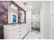 Contemporary bathroom with dual sink vanity, decorative wallpaper, and glass-enclosed shower at 1 Greenridge Rd, Greenwood Village, CO 80111