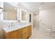Bright bathroom features double vanity, sleek mirrors with LED backlighting and a marble tiled walk-in shower at 1 Greenridge Rd, Greenwood Village, CO 80111