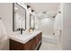 Modern bathroom featuring dual vanity, sleek black fixtures, and a shower-tub combination with tile surround at 1 Greenridge Rd, Greenwood Village, CO 80111