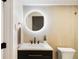 Stylish bathroom with a circular mirror, updated vanity, and modern fixtures, offering a spa-like experience at 1 Greenridge Rd, Greenwood Village, CO 80111