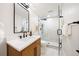 Modern bathroom featuring wood vanity, matte black faucet, and walk-in shower with a black shower system at 1 Greenridge Rd, Greenwood Village, CO 80111
