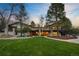 Beautiful home exterior featuring a well-manicured lawn and stone accents, surrounded by mature trees at 1 Greenridge Rd, Greenwood Village, CO 80111