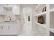 Modern kitchen with white cabinets, marble flooring, and an open layout that flows into the hallway at 1 Greenridge Rd, Greenwood Village, CO 80111
