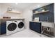 Well-equipped laundry room with modern washer and dryer, built-in storage, and stylish accents offering convenience at 1 Greenridge Rd, Greenwood Village, CO 80111