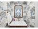 Elegant powder room with unique floral wallpaper, framed mirror, and marble countertop providing a luxurious touch at 1 Greenridge Rd, Greenwood Village, CO 80111