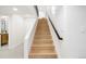 View of light wood staircase with white risers, white stringer, and black handrail leading to upper level at 1 Greenridge Rd, Greenwood Village, CO 80111