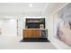 Basement wet bar area featuring wood cabinets, a wine cooler, and a stylish backsplash at 1 Greenridge Rd, Greenwood Village, CO 80111