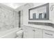 Updated bathroom with white cabinets, marble-look tile, and a bathtub at 5995 W Hampden Ave # 5I, Denver, CO 80227