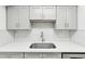 Kitchen features gray cabinets and a herringbone backsplash at 5995 W Hampden Ave # 5I, Denver, CO 80227