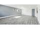 Bright living room with gray wood-look floors and a view to the kitchen at 5995 W Hampden Ave # 5I, Denver, CO 80227