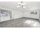 Open living room with gray wood-look floors and chandelier at 5995 W Hampden Ave # 5I, Denver, CO 80227