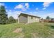 Expansive backyard featuring lush green grass, mature trees, and a well-maintained exterior at 1151 Buttercup Rd, Elizabeth, CO 80107
