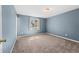 Light-filled bedroom with blue walls, carpet, and a window at 1151 Buttercup Rd, Elizabeth, CO 80107