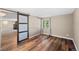 Bedroom with wood floors, barn door, and a window allowing natural light at 1151 Buttercup Rd, Elizabeth, CO 80107