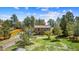 Charming two-story home with a deck, set amongst lush trees, and a green lawn at 1151 Buttercup Rd, Elizabeth, CO 80107