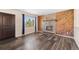 Cozy living room with stone fireplace, wood paneling, and laminate wood flooring at 1151 Buttercup Rd, Elizabeth, CO 80107