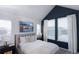 This bedroom features a blue accent wall, large windows, and a comfortable bed with neutral bedding and pillows at 11914 W 57Th Dr, Arvada, CO 80002
