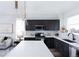 This is a modern kitchen featuring dark cabinets, stainless steel appliances, white countertops, and pendant lighting at 11914 W 57Th Dr, Arvada, CO 80002