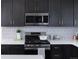 This kitchen offers dark cabinets with gold hardware, stainless steel appliances, and a white countertop at 11914 W 57Th Dr, Arvada, CO 80002