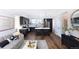 This open-concept living space features a kitchen with dark cabinets and a living room with stylish decor at 11914 W 57Th Dr, Arvada, CO 80002