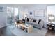 This is a well-lit living room with a gray sofa, modern furnishings, and a view of the outdoors at 11914 W 57Th Dr, Arvada, CO 80002