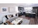 This is a modern living room and kitchen with a gray sofa, patterned rug, dark cabinets, and stainless appliances at 11914 W 57Th Dr, Arvada, CO 80002