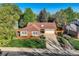 Aerial view of brick home featuring a well-manicured lawn, lush landscaping, and mature trees at 2093 S Holland St, Lakewood, CO 80227