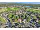 Wide aerial shot of the neighborhood showing surrounding houses, trees, and nearby lake and playing fields at 2093 S Holland St, Lakewood, CO 80227