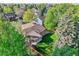 Overhead aerial view of the house and fenced backyard with established trees and a patio at 2093 S Holland St, Lakewood, CO 80227