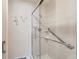 Walk-in shower with glass door, grab bars, and white tile at 2093 S Holland St, Lakewood, CO 80227
