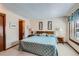Comfortable bedroom with a window, a light blue bedspread, and wood trimmed furniture at 2093 S Holland St, Lakewood, CO 80227