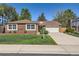 Charming brick home featuring a well-manicured lawn and a two-car garage and lush landscaping at 2093 S Holland St, Lakewood, CO 80227
