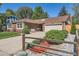 Charming brick home featuring a well-manicured lawn and a two-car garage and mature landscaping at 2093 S Holland St, Lakewood, CO 80227