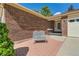 Charming brick home featuring a front porch with a bench and manicured landscaping at 2093 S Holland St, Lakewood, CO 80227