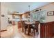 Open kitchen with wooden cabinets and flooring, adjacent to a dining area with natural light at 2093 S Holland St, Lakewood, CO 80227