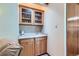 Home wet bar with glass door cabinets, sink, and generous storage at 2093 S Holland St, Lakewood, CO 80227