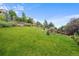 Expansive backyard featuring lush green grass, mature trees, and a fenced perimeter at 2575 Mccracken Ln, Castle Rock, CO 80104