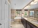 Bathroom featuring a luxurious soaking tub, walk-in shower, and double vanity with granite countertops at 2575 Mccracken Ln, Castle Rock, CO 80104