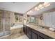A well-lit bathroom features a double sink vanity, separate shower, and a soaking tub with a window view at 2575 Mccracken Ln, Castle Rock, CO 80104